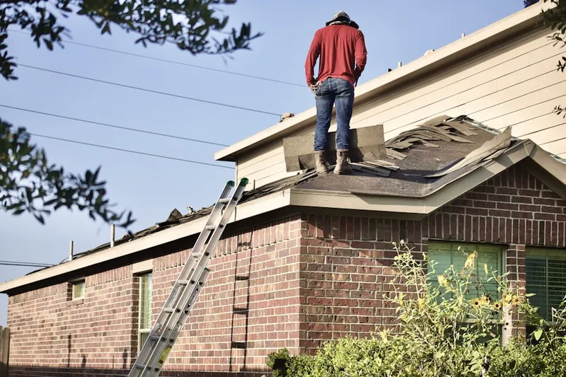 Professional roofer working on a residential roof in Harvard